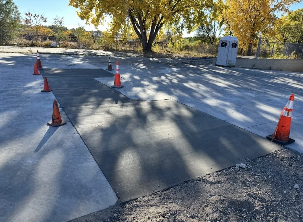 New concrete driveway with traffic cones and fall trees in Colorado Springs